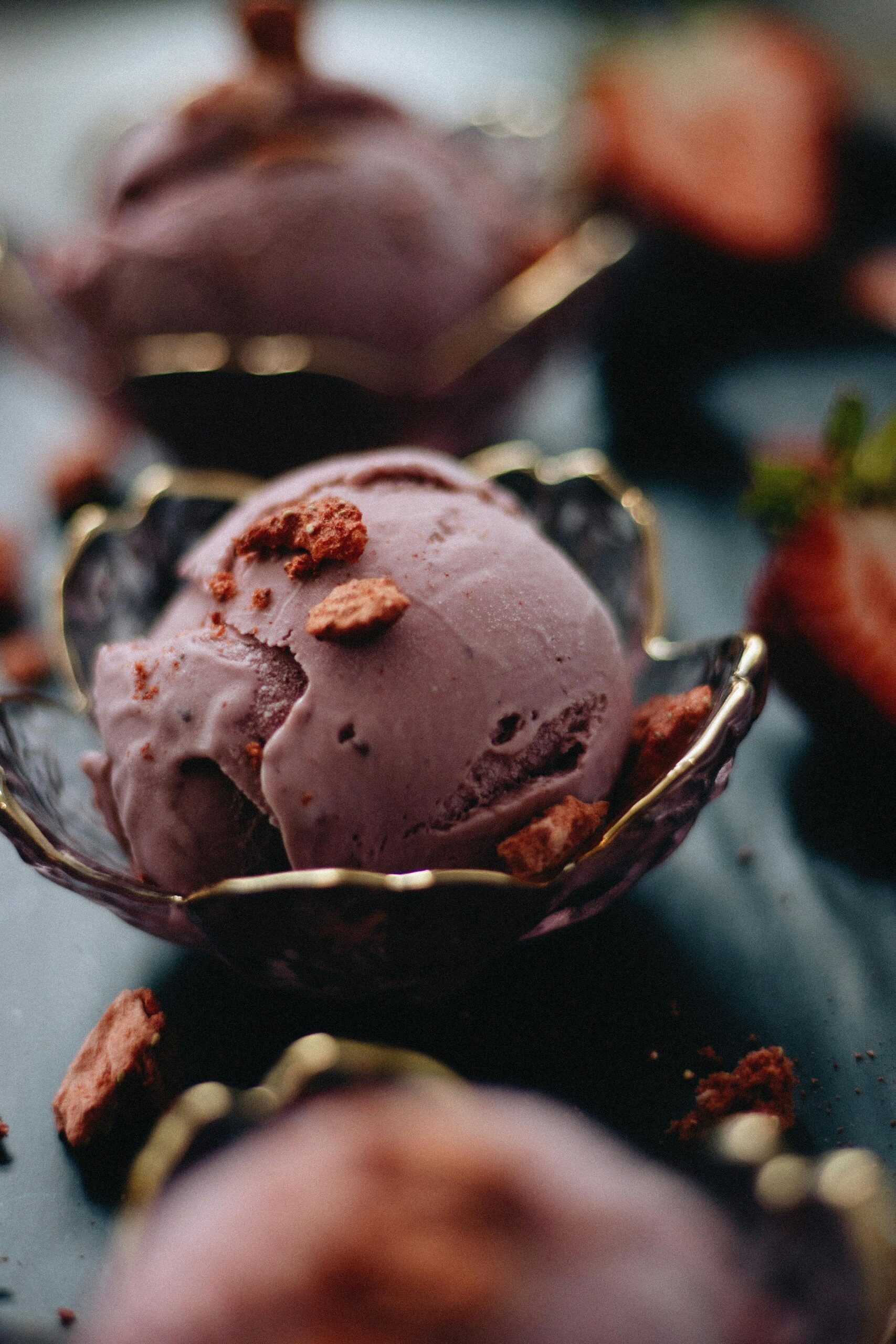 Close-up of gourmet strawberry ice cream in a decorative bowl, showcasing artisanal dessert styling.